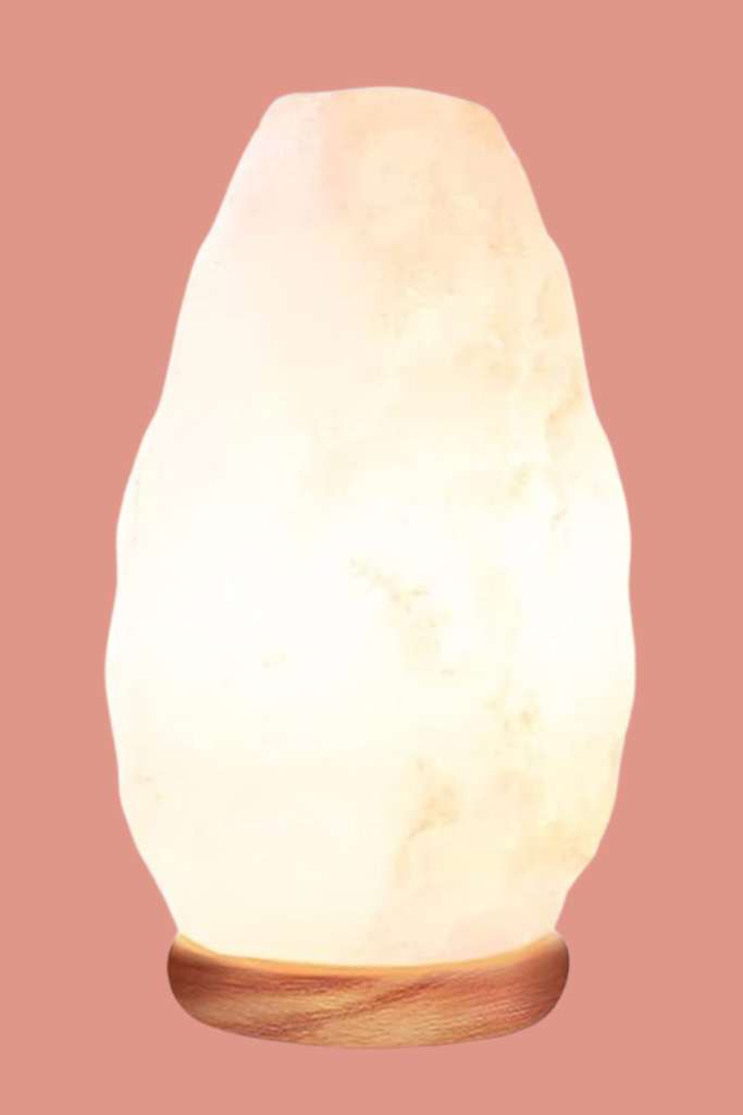 Warm Himalayan salt lamp glowing softly on a wooden base, perfect for cozy book nooks