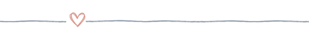 A horizontal blue-gray divider line with a soft pink heart in the center, used to visually break up content in reading and memory-focused resources.