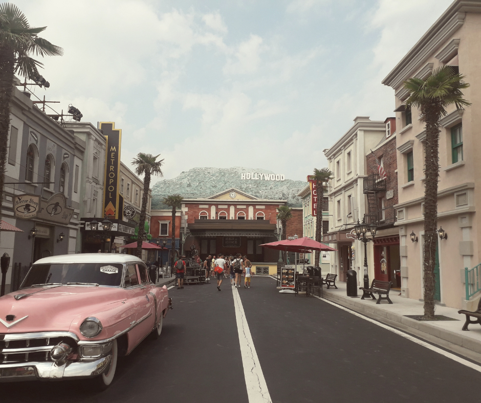 Hollywood street with vintage pink car and Hollywood sign, evoking romance, nostalgia, and second chance love story vibes.