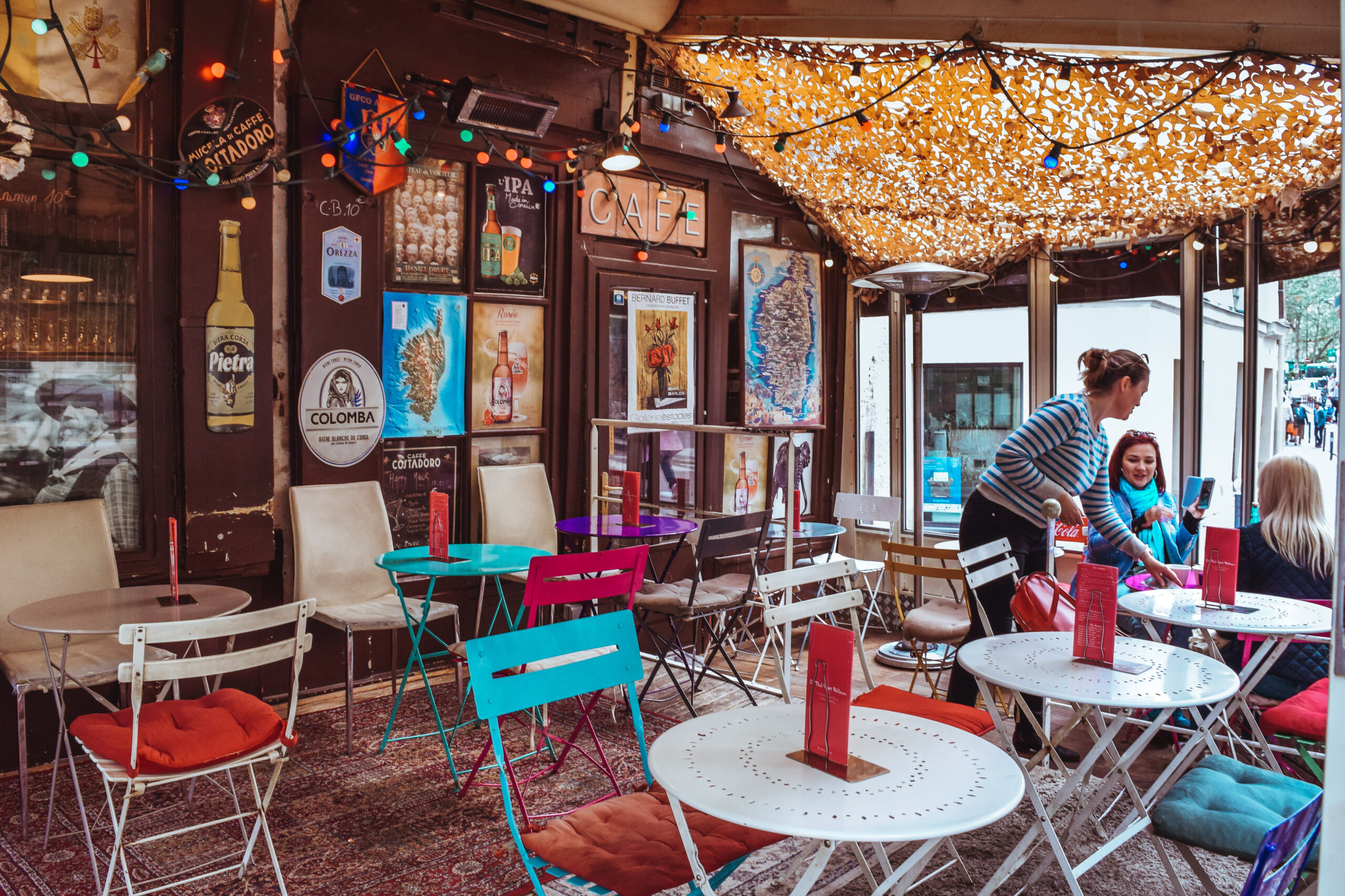 Colorful café tables and chairs creating cozy book club vibes, the perfect inspiration for how to start a book club gathering.