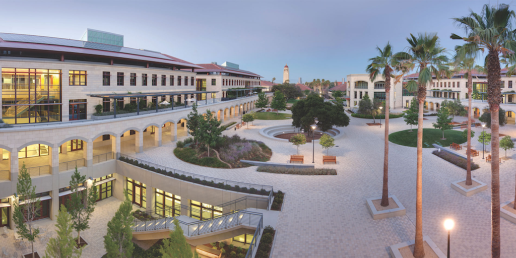 Modern courtyard at Stanford University with palm trees, arches, and open spaces, evoking the collegiate atmosphere in Deep End by Ali Hazelwood, a romance book set on campus.